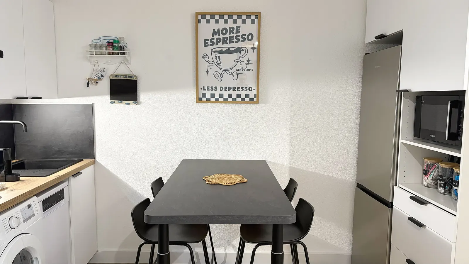 Cuisine équipée avec table haute et rangements blancs
