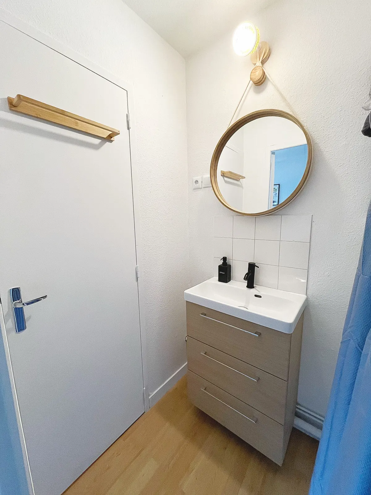 Shower room with basin and round mirror
